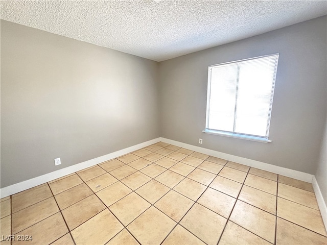 tiled spare room with a textured ceiling