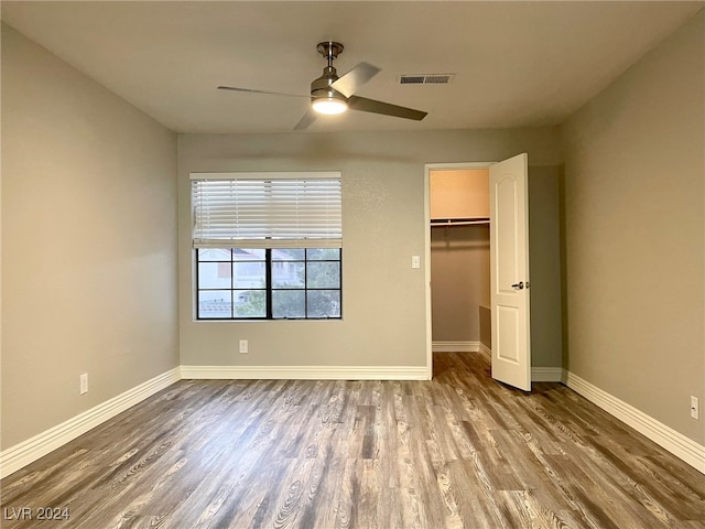 unfurnished bedroom featuring hardwood / wood-style flooring, ceiling fan, and a closet