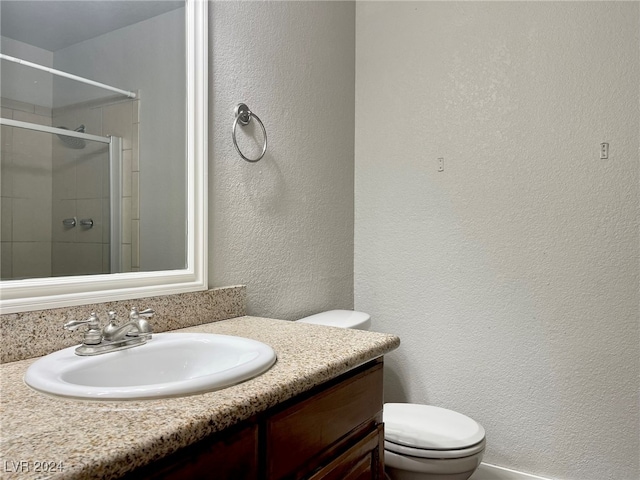 bathroom with an enclosed shower, vanity, and toilet