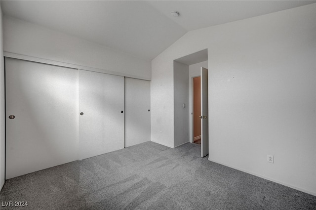 unfurnished bedroom with carpet floors, lofted ceiling, and a closet