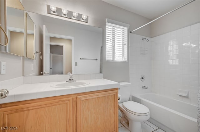 full bathroom featuring tiled shower / bath, tile patterned floors, vanity, and toilet