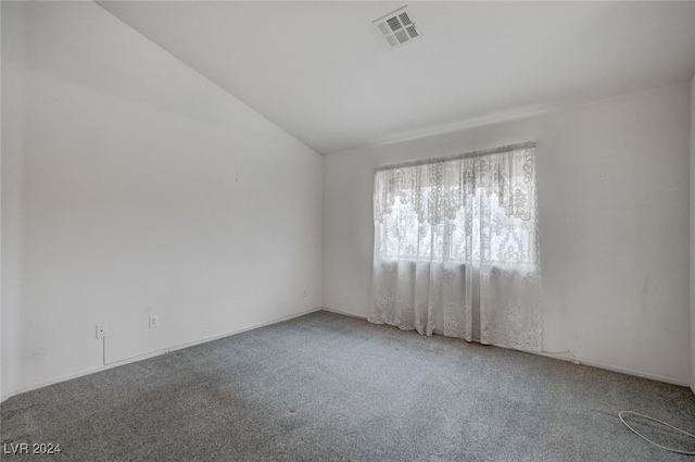 spare room with carpet floors and vaulted ceiling