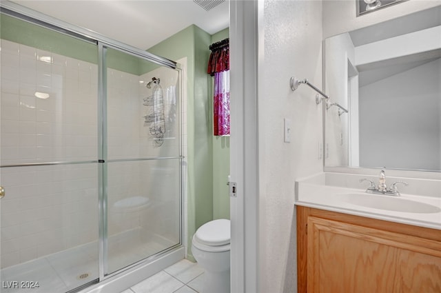 bathroom featuring tile patterned flooring, an enclosed shower, vanity, and toilet