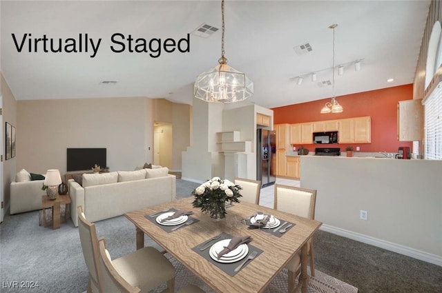 dining area featuring a notable chandelier, carpet floors, and rail lighting