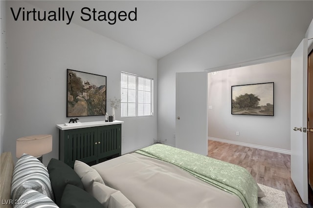 bedroom featuring hardwood / wood-style flooring and lofted ceiling