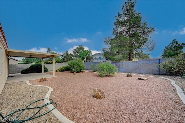 view of yard with ceiling fan and a patio area