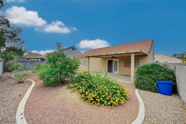 rear view of property with ceiling fan and a patio area