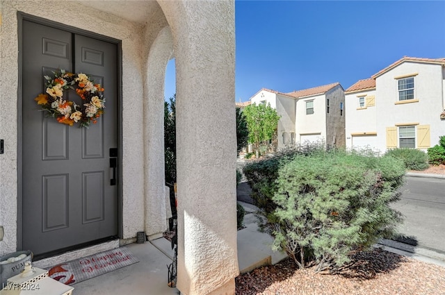 entrance to property with a residential view and stucco siding