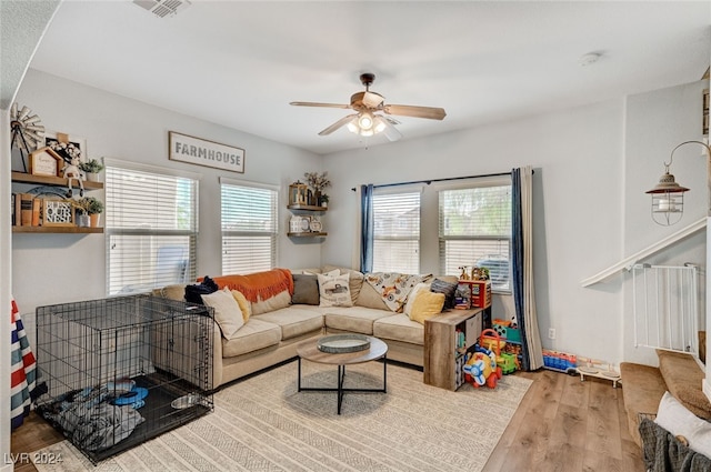 living area featuring ceiling fan, plenty of natural light, wood finished floors, and visible vents