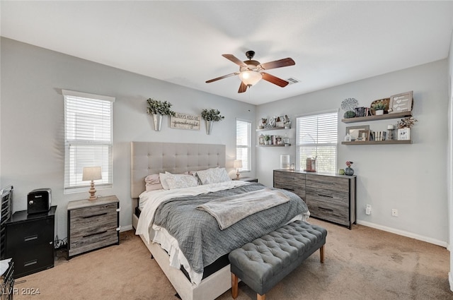 bedroom featuring baseboards, visible vents, ceiling fan, and light colored carpet