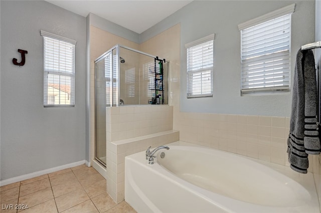 full bath featuring a garden tub, tile patterned flooring, a shower stall, and baseboards