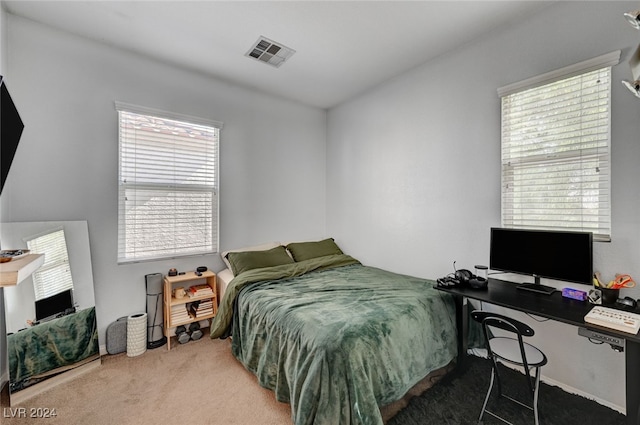 carpeted bedroom featuring visible vents