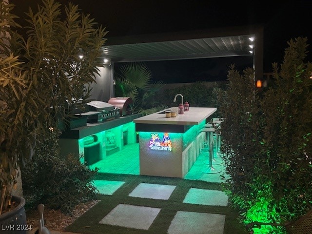 pool at twilight with sink and a patio area