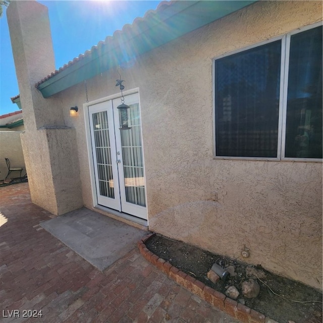 property entrance featuring a patio and french doors