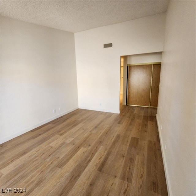 empty room with a textured ceiling and hardwood / wood-style floors