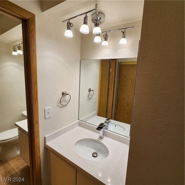 bathroom featuring vanity and toilet