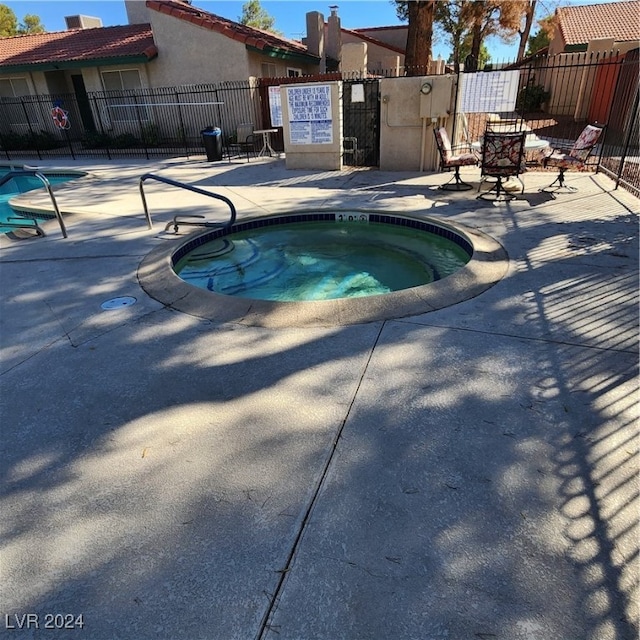 view of swimming pool with a patio and a community hot tub