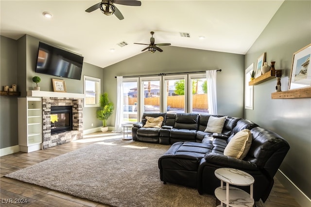 living room featuring wood-type flooring, a fireplace, vaulted ceiling, and ceiling fan