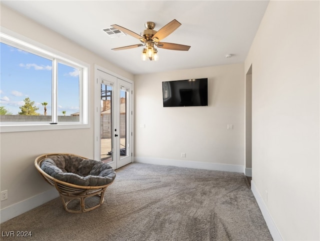 living area featuring ceiling fan, french doors, and carpet