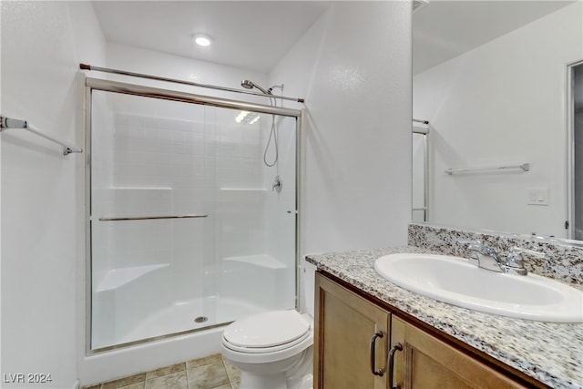 bathroom featuring toilet, vanity, an enclosed shower, and tile patterned flooring