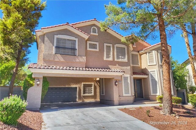 1337 Via Savona Dr, Henderson, NV 89052 - view of front of house with a tile roof, a garage, driveway, and stucco siding