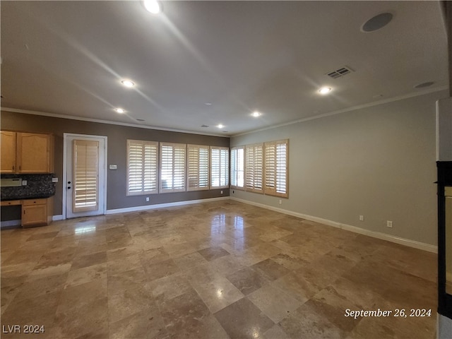 unfurnished living room featuring crown molding