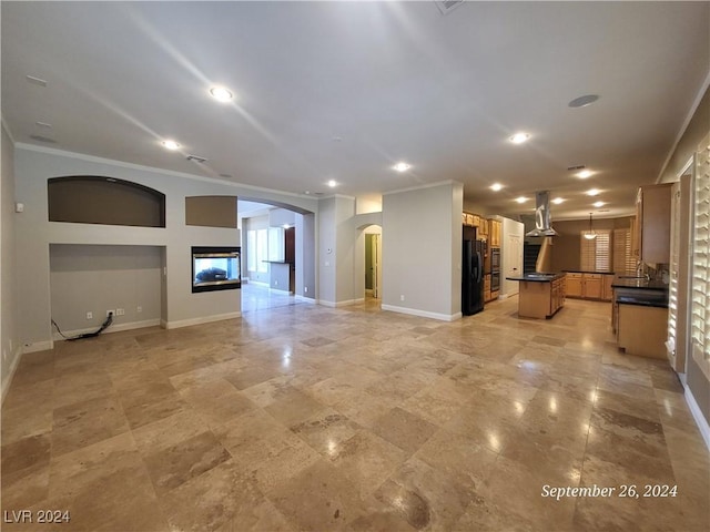 1337 Via Savona Dr, Henderson, NV 89052 - unfurnished living room with arched walkways, crown molding, baseboards, recessed lighting, and a glass covered fireplace