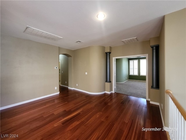 empty room featuring a wood stove, dark hardwood / wood-style flooring, and a textured ceiling