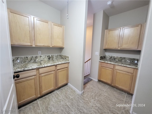 kitchen featuring light stone counters, light brown cabinets, and light tile patterned floors