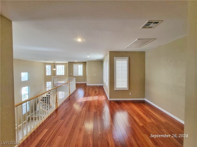 unfurnished room featuring hardwood / wood-style flooring and a textured ceiling