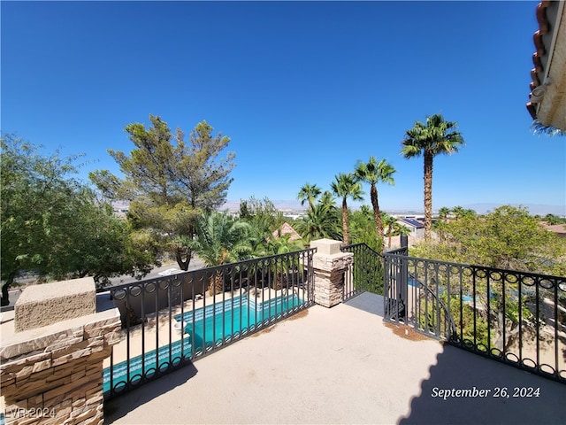 view of patio / terrace featuring a fenced in pool and a balcony