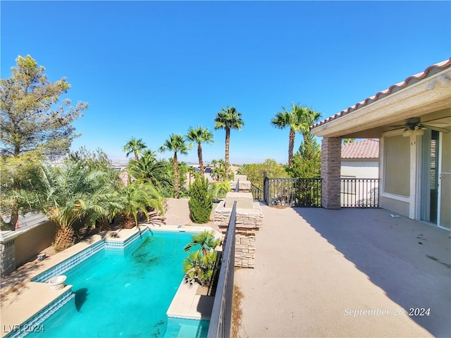 view of swimming pool featuring ceiling fan and a patio area