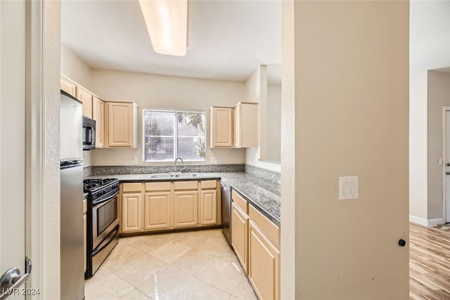 kitchen with appliances with stainless steel finishes, light brown cabinetry, and sink