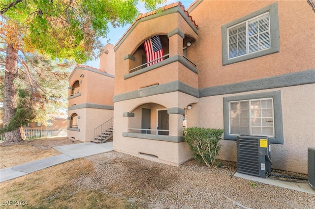 view of front of home featuring cooling unit and a balcony