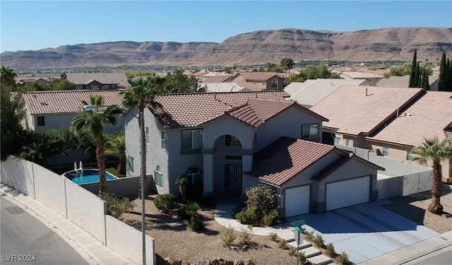 view of front of property with a garage and a mountain view