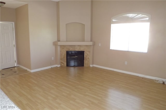 unfurnished living room featuring light hardwood / wood-style floors and a high end fireplace