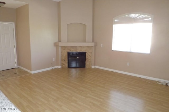 75 N Valle Verde Dr Unit 225, Henderson, NV 89074 - unfurnished living room with a tiled fireplace, wood finished floors, and baseboards