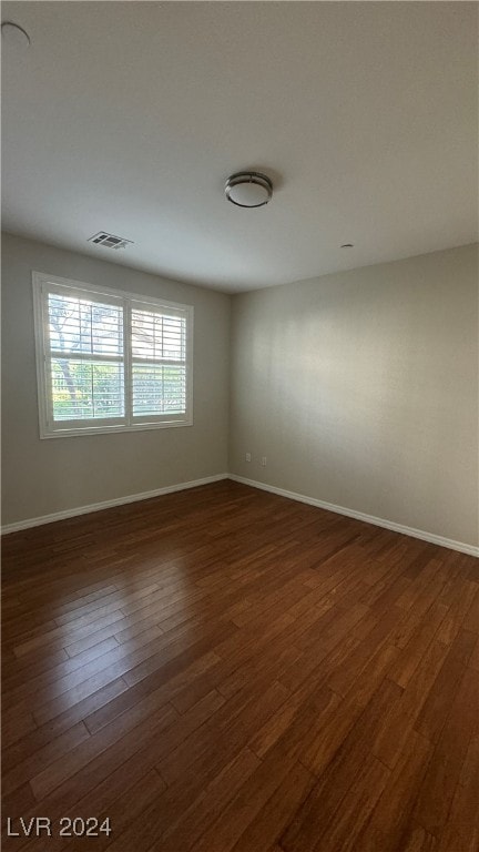 spare room with dark hardwood / wood-style flooring