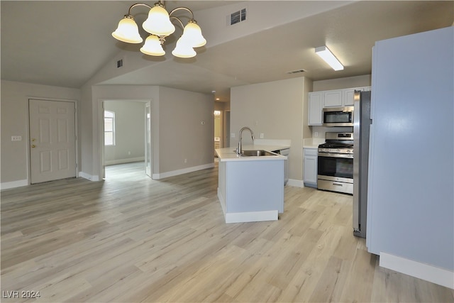 kitchen with stainless steel appliances, sink, decorative light fixtures, light hardwood / wood-style floors, and white cabinetry