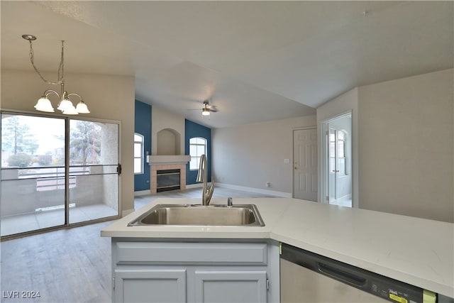 kitchen featuring sink, light hardwood / wood-style flooring, dishwasher, white cabinets, and hanging light fixtures