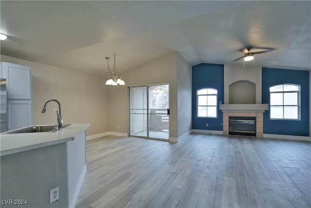 kitchen featuring decorative light fixtures, light hardwood / wood-style floors, sink, and a wealth of natural light