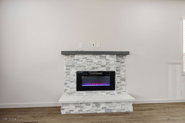 room details featuring a stone fireplace and hardwood / wood-style floors