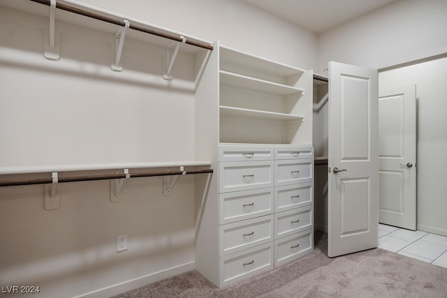 walk in closet featuring light colored carpet