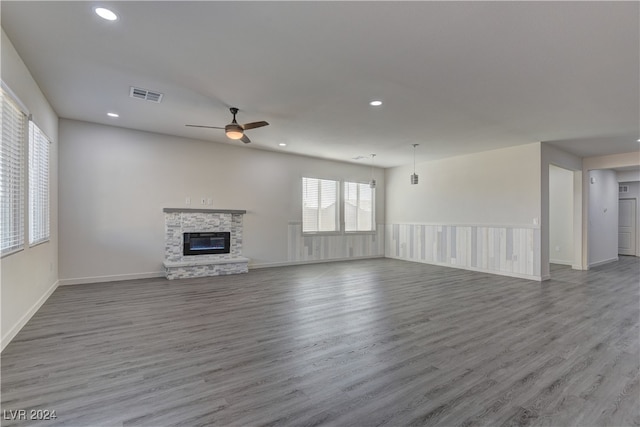 unfurnished living room featuring a fireplace, ceiling fan, and wood-type flooring