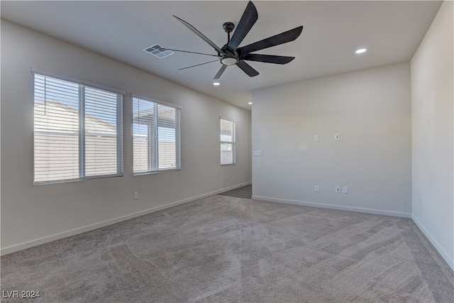 spare room featuring ceiling fan and light carpet