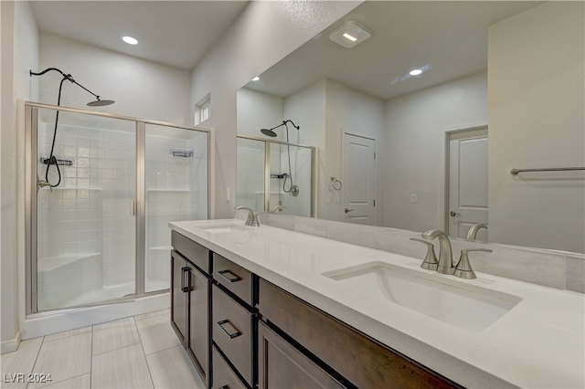 bathroom featuring tile patterned floors, an enclosed shower, and vanity