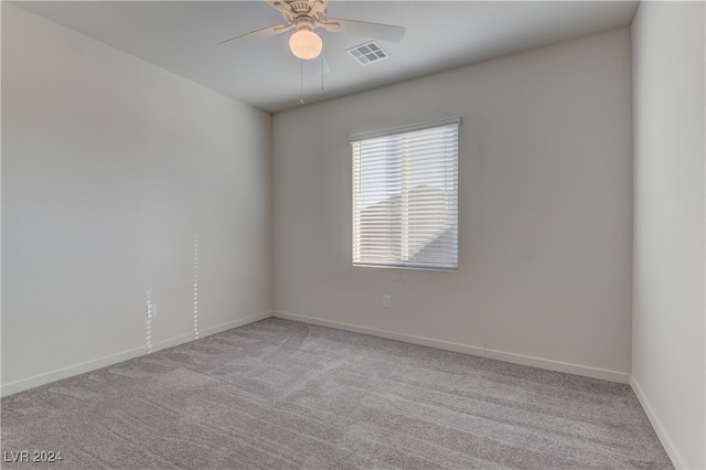 carpeted spare room with ceiling fan