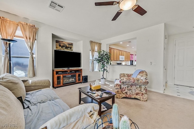 living room with ceiling fan, light colored carpet, and a wealth of natural light