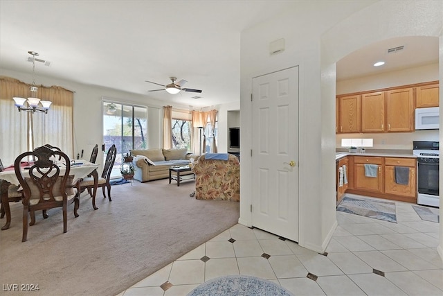 kitchen with light carpet, ceiling fan with notable chandelier, pendant lighting, and white appliances