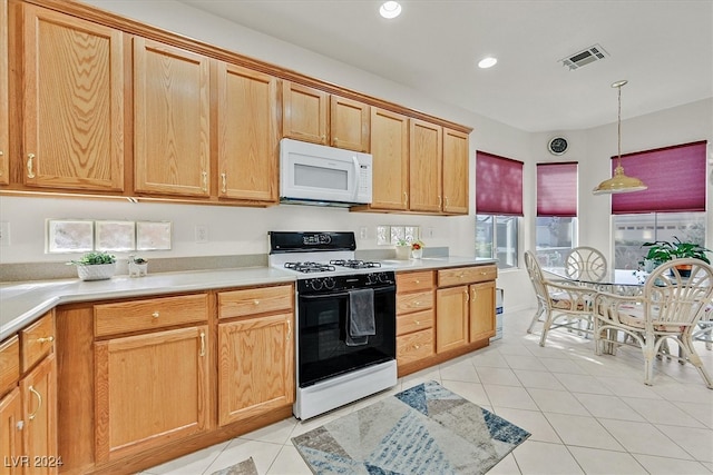 kitchen with light tile patterned floors, white appliances, and pendant lighting